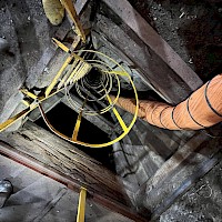 Promontorio - view down 55 m-deep Balvanera shaft. Note historical timbered shaft walls, recently installed marine ladder and ventilation duct. The ladder reaches 45 m depth and provides access to 3 lower levels at 12, 20, and 45 m.